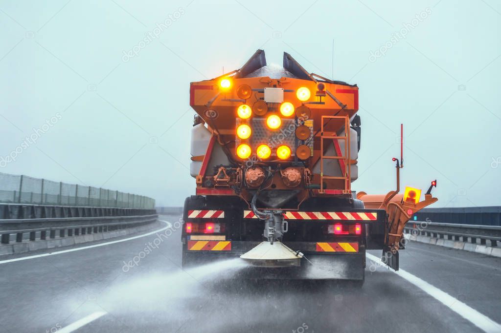 Streugerät verteilt Streumittel auf Fahrbahn
